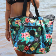 a floral-patterned oversized beach bag with inside pockets and extra long straps by the beach