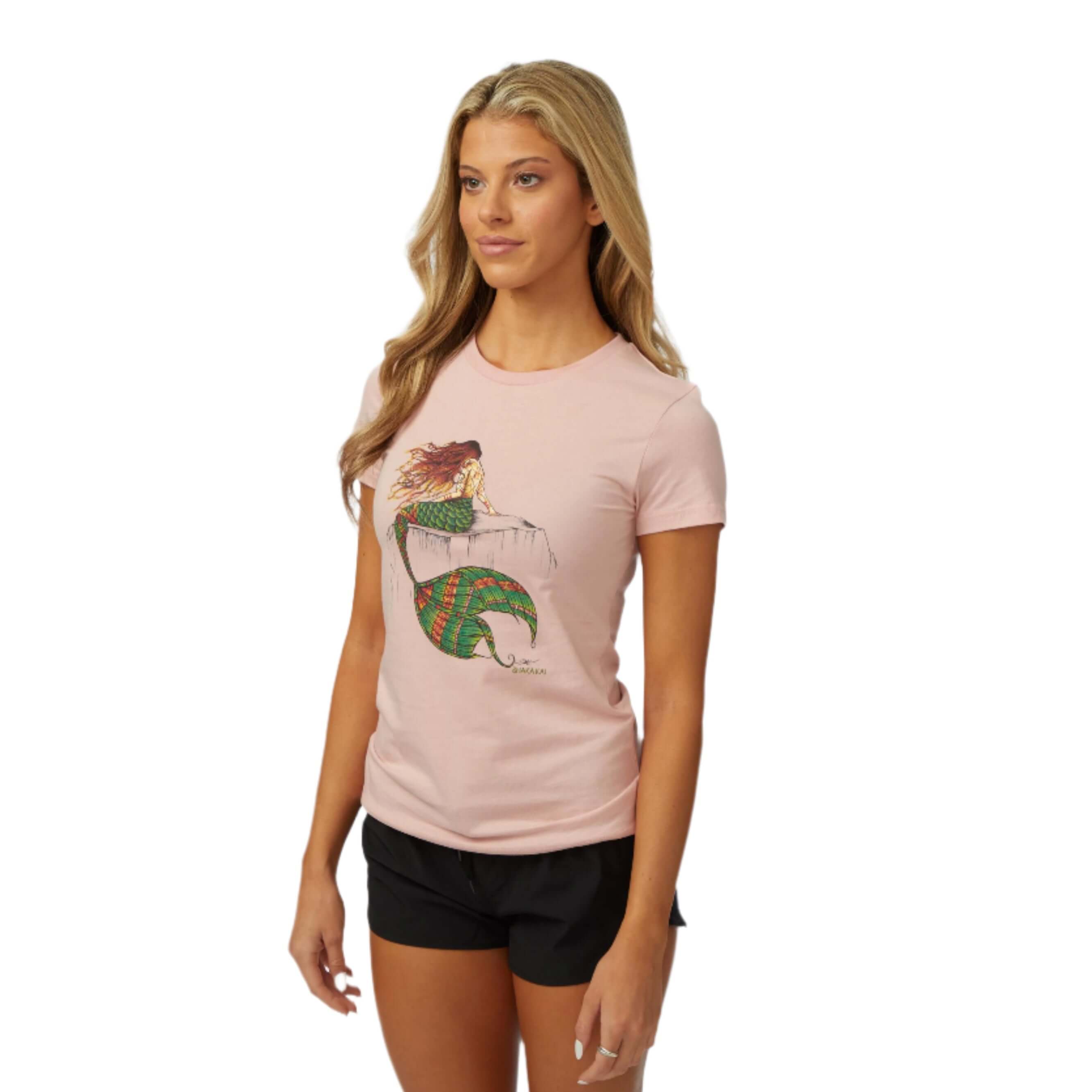 Woman wearing the DaveL Nixi T-Shirt with original mermaid art in a relaxed pose, showcasing island vibes and comfort.