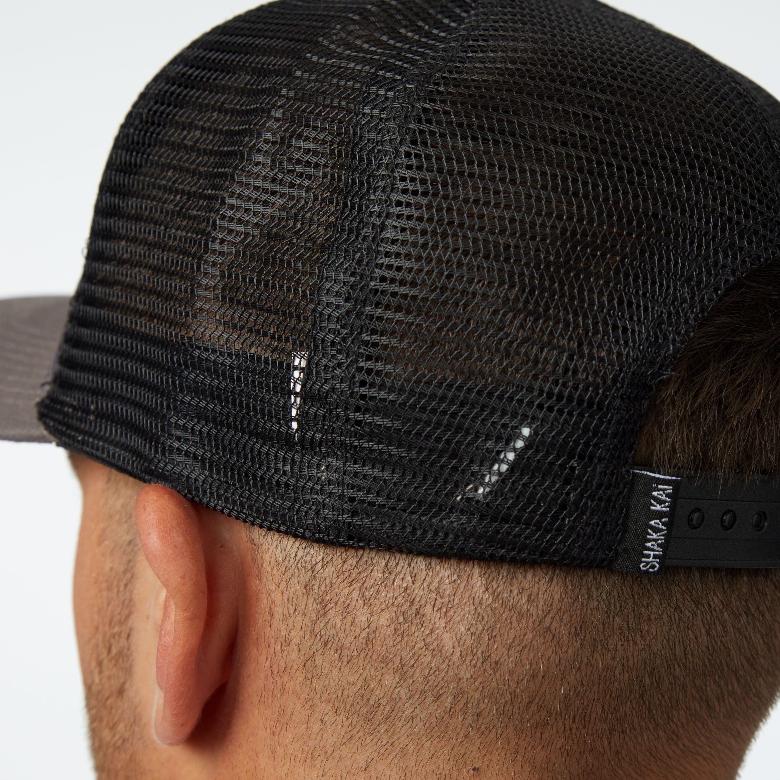 Back view of the Makau Trucker Hat showcasing its mesh design and adjustable strap.