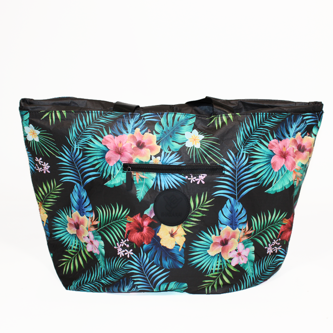 a floral-patterned oversized beach bag with inside pockets and extra long straps by the beach