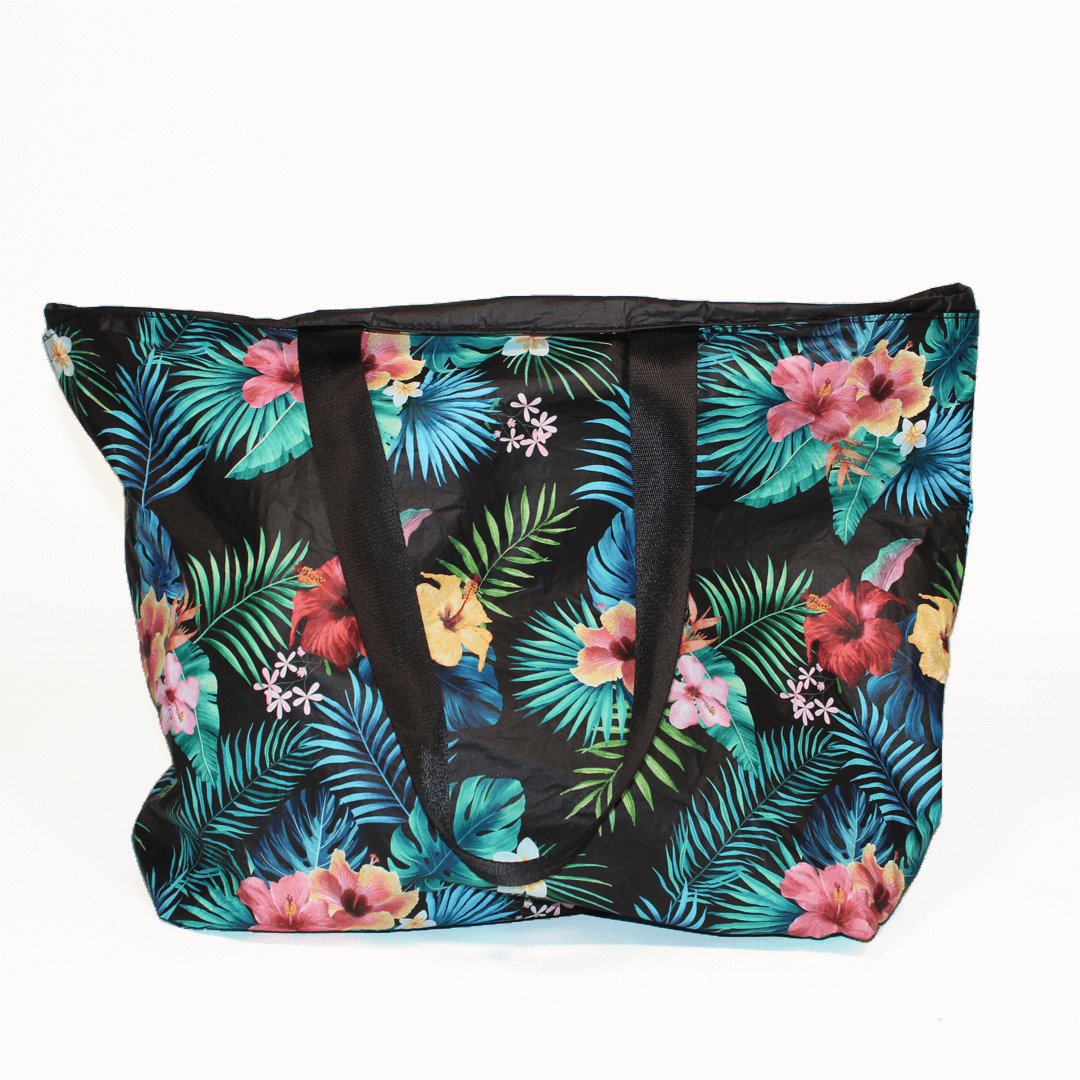 a floral-patterned oversized beach bag with inside pockets and extra long straps by the beach